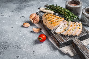Kesme tahtasında dilimlenmiş hindi ızgara göğüs bifteği. Gri arka plan. Üst Manzara. Boşluğu kopyala