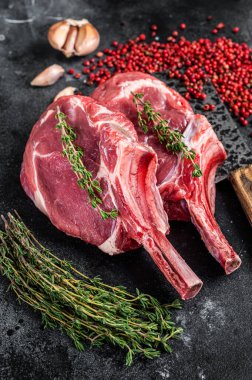 Et satırında çiğ Tomahawk pirzola bifteği. Siyah arka plan. Üst görünüm