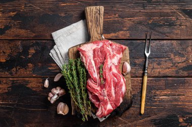 Çiğ kemiksiz kuzu eti, tahta tahtada çiğ boyun eti. Siyah arka plan. Üst görünüm