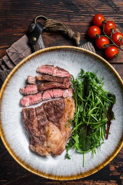 Barbekü kızarmış Chuck Roll bifteği ve tabakta salata. Ahşap arka plan. Üst görünüm