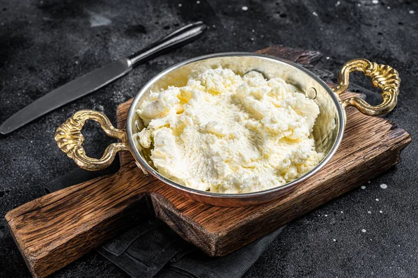 Kaymak Nata coagulada, creme de manteiga em uma panela rústica. Fundo preto. Vista superior — Fotografia de Stock