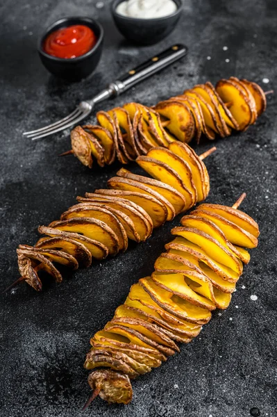 Roasted Tornado or twisted potatoes with ketchup sauce. Black background. Top view — Stock Photo, Image