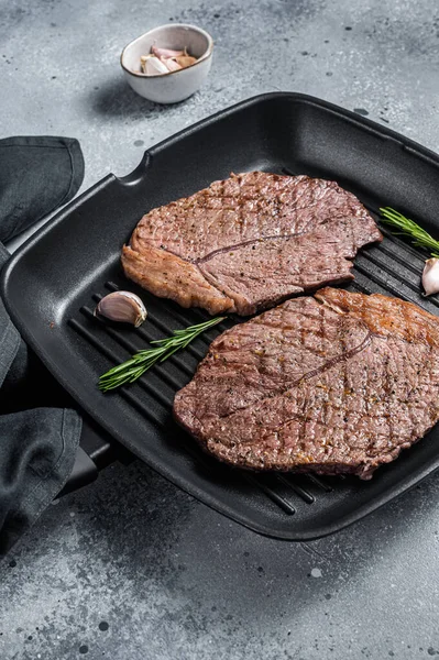 Roasted on grill skillet beef marbled meat steaks. Gray background. Top view — Stock Photo, Image