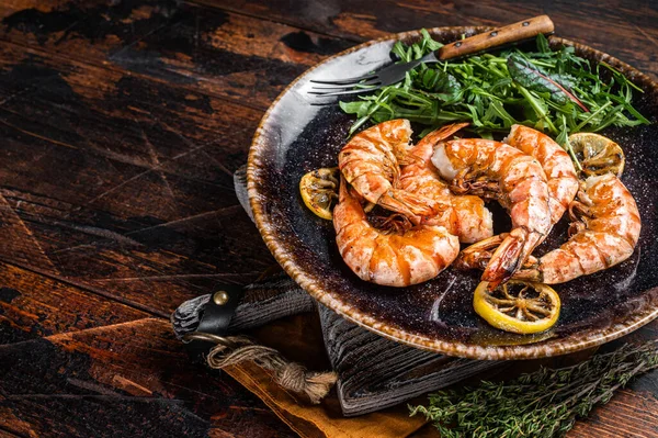 Spicy garlic Giant shrimps prawns in plate with salad. Wooden background. Top view. Free copy space — Fotografia de Stock