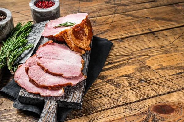 Cold Smoked pork sirloin meat with herbs on rustic board. Wooden background. Top view. Copy space — стоковое фото