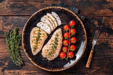 Protein yemeği - domatesli ızgara hindi göğsü bifteği. Ahşap arka plan. Üst görünüm