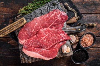 Biftek, kasap kesim tahtasındaki baharatlı çiğ et. Ahşap arka plan. Üst görünüm