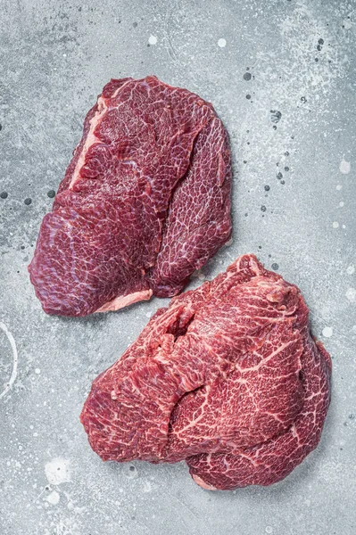 肉屋のテーブルの上で伝統的なドイツの生の牛肉の頬。灰色の背景。トップ表示 — ストック写真