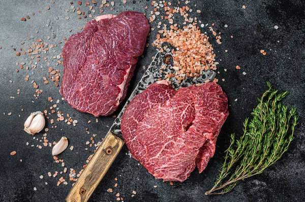 Raw Beef cheeks, fresh veal meat on butcher cleaver. Black background. Top view — Foto Stock