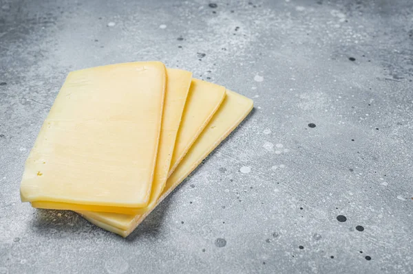 Uncooked Raclette Swiss cheese slices. Gray background. Top view. Copy space — Fotografia de Stock