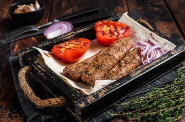 Tahta tepside Türk kebabı, ekmek, soğan ve domates. Ahşap arka plan. en üstteki görünüm