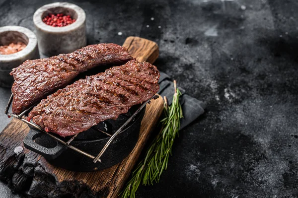 Grilled Machete skirt steak on grill. Black background. Top view. Copy space — Stock Photo, Image