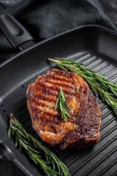 Roasted rib eye steak, ribeye beef meat in a grill pan. Black background. top view — Stock Photo, Image