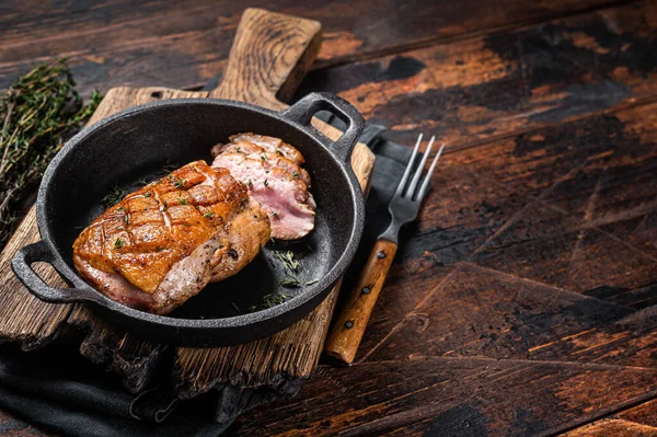 Duck breast roasted in a pan, poultry meat steak with herbs. Wooden background. Top view. Copy space — Stock Photo, Image