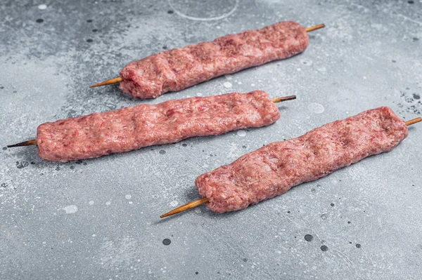 Raw Turkish Adana shish kebab on butcher table. Gray background. top view — Stock Photo, Image