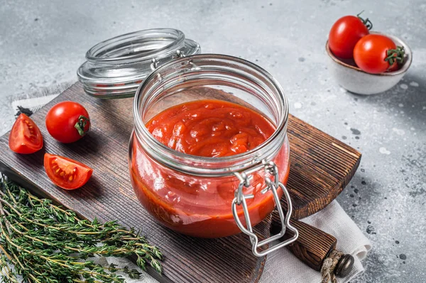 Homemade red tomato sauce with basil in glass jar. Gray background. Top view — Stockfoto