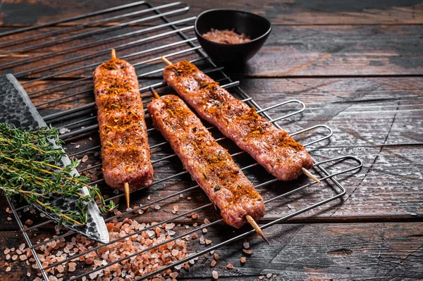 Uncooked Raw Urfa shish kebab on a grill with pink salt. Wooden background. top view. Copy space — Zdjęcie stockowe