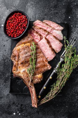 Izgara Tomahawk bifteği, kekikli kaburga. Siyah arka plan. Üst görünüm