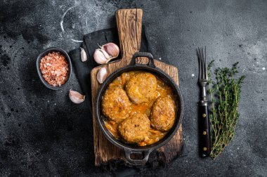 Tavada domates soslu ton balıklı balık köftesi. Siyah arka plan. Üst görünüm