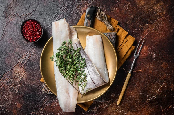 Filete de pescado blanco, pescado crudo de eglefino en plato con romero y tomillo. Fondo oscuro. Vista superior —  Fotos de Stock