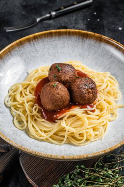Bitki temelli et ve domates sosundan köfteli vejetaryen makarna. Siyah arka plan. Üst görünüm