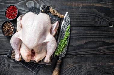 Çiğ tavuk, ahşap bir tahtanın üzerinde otlarla birlikte kümes hayvanları. Kara tahta arka plan. Üst Manzara. Boşluğu kopyala