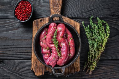 Çiğ koyun fileto fileto fileto et, kuzu fileto ve kekik. Siyah ahşap arka plan. Üst görünüm