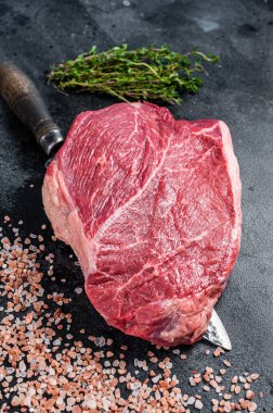 Mezbaha bıçağında çiğ biftek. Siyah arka plan. Üst görünüm