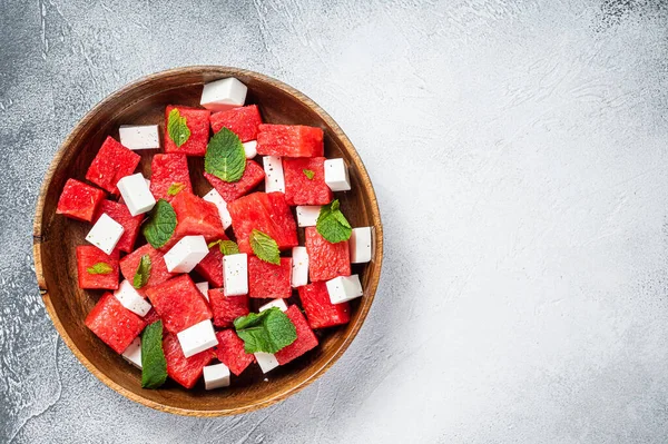 Watermeloen Salade met feta kaas in een houten bord. Witte achtergrond. Bovenaanzicht. Kopieerruimte — Stockfoto