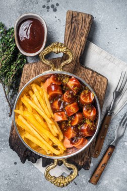 Geleneksel Alman baharatlı sosisi, patates cipsi ya da tavada patates kızartmasıyla servis edilir. Gri arka plan. Üst görünüm