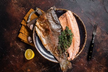 Kızarmış alabalık fileto, kekik ve limonlu ızgara balık. Karanlık arka plan. Üst görünüm