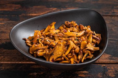 Kızarmış orman mantarı ve şifalı otlar. Ahşap arka plan. Üst görünüm