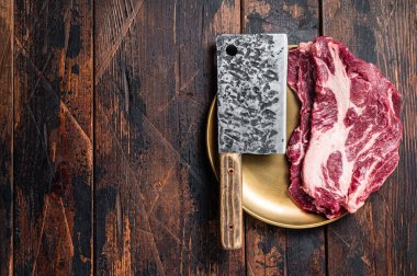 Kasap masasında çiğ mermer biftek, pişmemiş sığır eti, gözleme biftek. Ahşap arka plan. Üst Manzara. Boşluğu kopyala