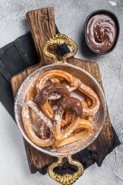 Çikolatalı Churros tavada tipik İspanyol tatlı atıştırmalığı. Gri arka plan. Üst görünüm