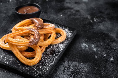 Geleneksel Meksika usulü çikolatalı churros. Siyah arka plan. Üst Manzara. Boşluğu kopyala
