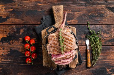 Izgara Tomahawk bifteği ve otlar. Ahşap arka plan. Üst görünüm