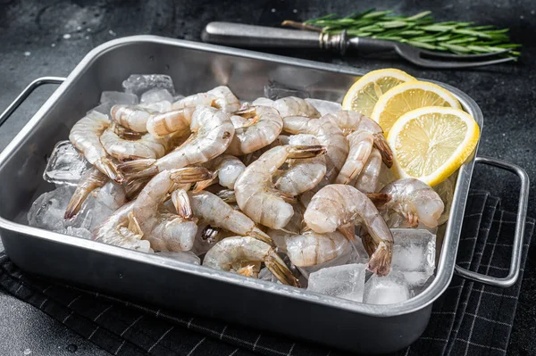Kuyruğu buzda soyulmuş çiğ Pasifik beyaz karidesi. Siyah arka plan. Üst görünüm