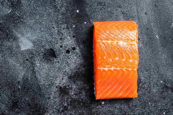 Bistecche di filetto di salmone crudo sul tavolo della cucina. Fondo nero. Vista dall'alto. Copia spazio — Foto Stock
