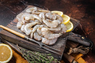 Çiğ kaplan beyaz karides ve otlar. Karanlık arka plan. Üst görünüm