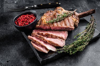 Grilled Tomahawk Beef Steak, Rib eye with thyme. Black background. Top view clipart