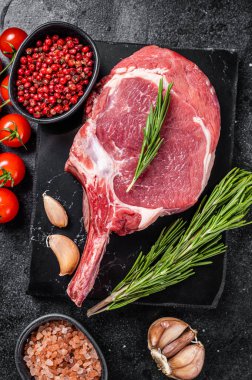 Çiğ kaburga ya da baharatlı Tomahawk bifteği pişirmek. Siyah arka plan. Üst görünüm