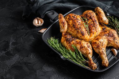 Barbekü serpilmiş ızgara tavada bütün tavuk. Siyah arka plan. Üst Manzara. Boşluğu kopyala