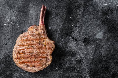 Barbekü ızgara Tomahawk bifteği kasap masasında. Siyah arka plan. Üst Manzara. Boşluğu kopyala