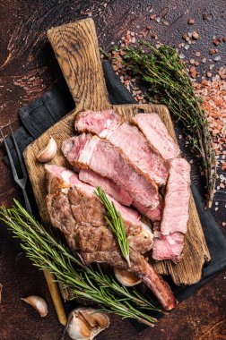 Barbekü ızgara Tomahawk bifteği, tahta bir tahtada pirzola. Karanlık arka plan. Üst görünüm