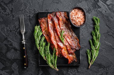 Kızarmış, çıtır çıtır domuz pastırması. Siyah arka plan. Üst görünüm