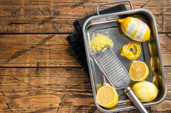 Cozinhar com Lemon Zest ralado e casca em espiral na bandeja da cozinha. Fundo de madeira. Vista superior. Espaço de cópia — Fotografia de Stock