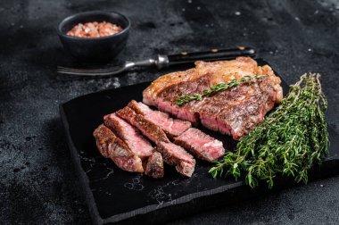 Kızarmış bbq Chuck Roll bifteği ve otlar. Siyah arka plan. Üst görünüm