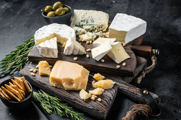Delicious Cheese board. Assortment of cheese, camembert, brie, Gorgonzola, parmesan, olives, nuts and herbs. Black background. Top view — Fotografia de Stock