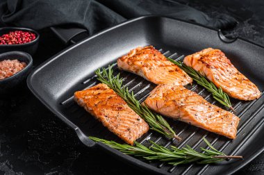 Kızarmış somon filetosu ızgara tavada biftek. Siyah arka plan. Üst görünüm