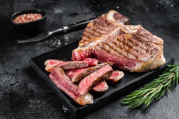 T hueso carne de res a la parrilla Filete, cocido Porterhouse en un tablero de mármol. Fondo negro. Vista superior —  Fotos de Stock